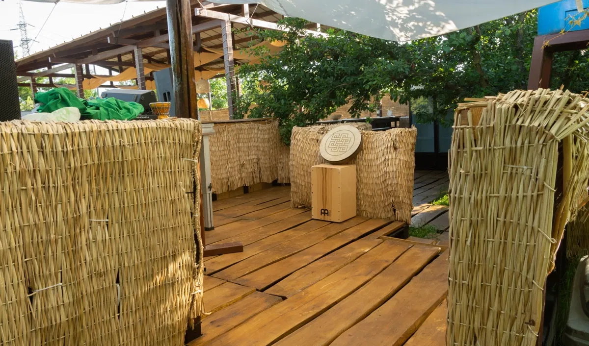 Decking de lemn cu paravane de stuf și vegetație